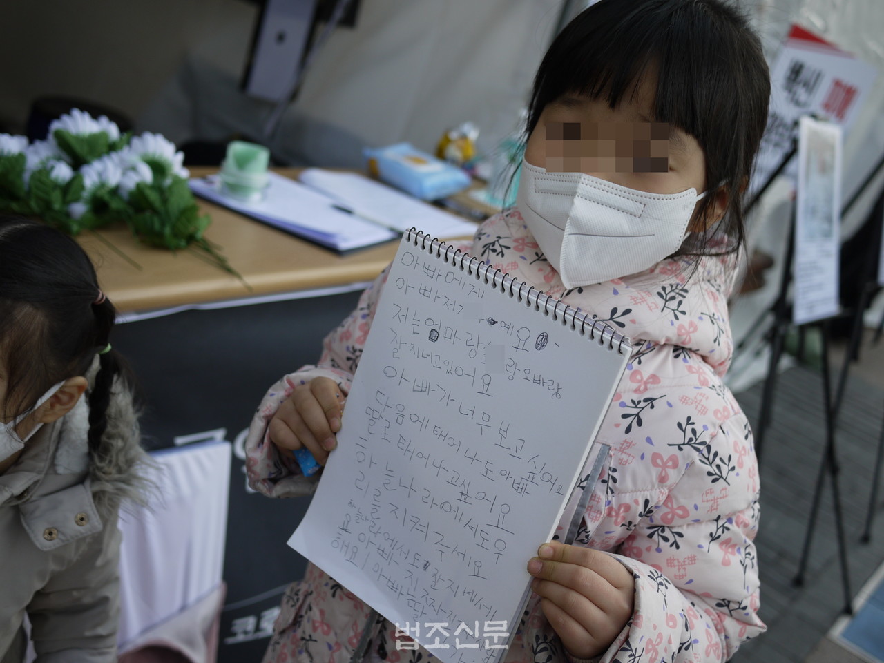  12일 '코로나19 백신 희생자 추모식'에 참석한 故허유창 씨의 딸이 손수 쓴 추모시를 보여주고 있다. 
