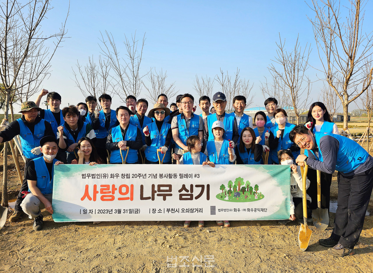 법무법인 화우와 화우공익재단이 31일 경기 부천시 김포공항 인근에서 나무 20그루를 심고 기념사진을 찍고 있다(사진: 화우 제공)